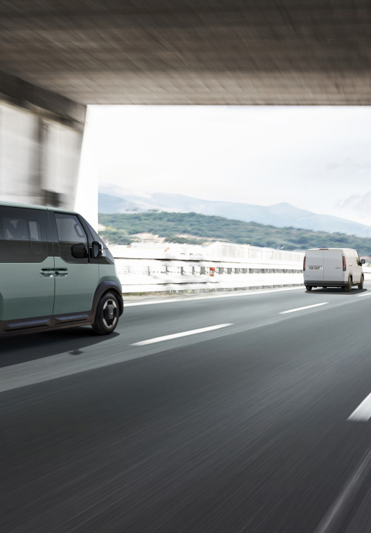 Kia PV5 WAV fährt auf der Autobahn – der Autobahnassistent hält Geschwindigkeit, Abstand und Spurposition.